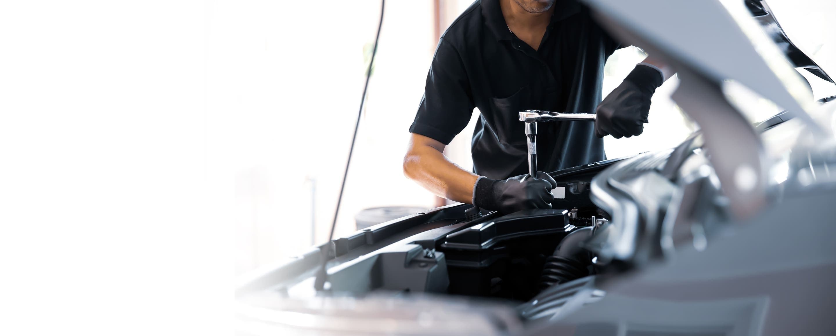 Mechaniker bei der Arbeit an einem Fahrzeugmotor in der AUTO AUA Werkstatt